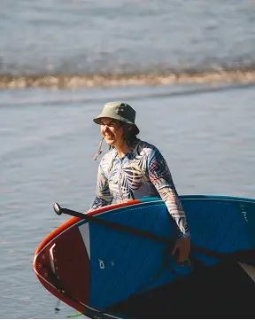 Joss Alabi walking out of the water with her SUP board