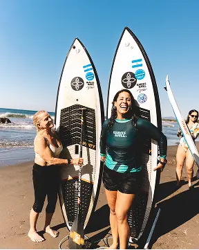 Joss Alabi smiling with SUP surf guests and their boards